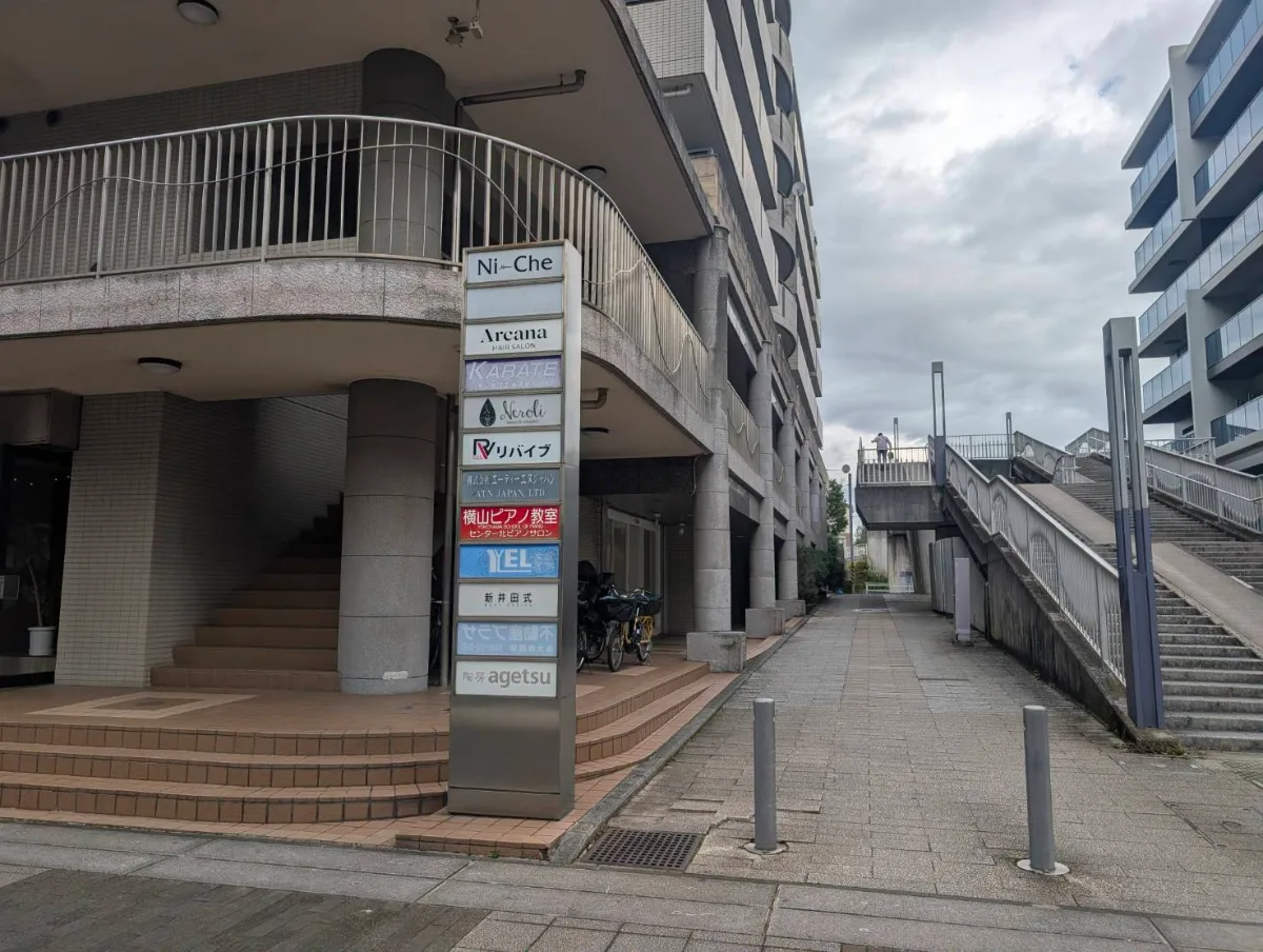 センター北ピアノサロンの入口付近。建物の看板に「横山ピアノ教室 センター北ピアノサロン」と出ている